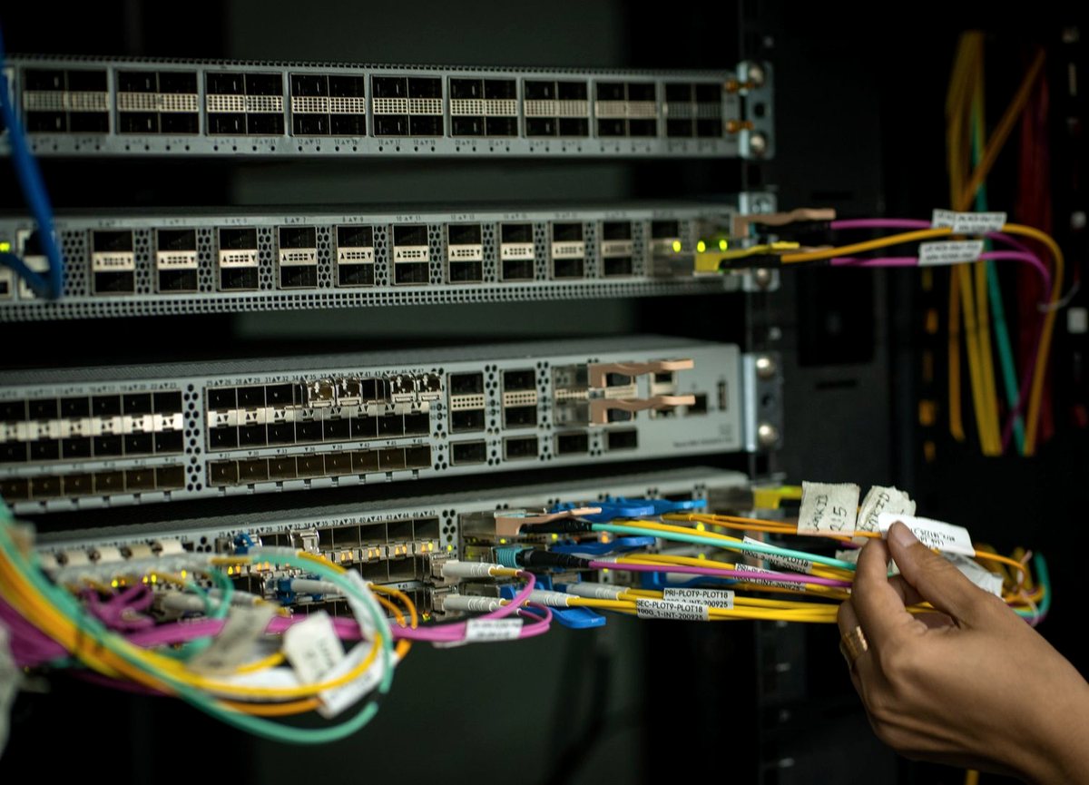 Técnico empalmando fibra óptica con una empalmadora de fusión durante una instalación FTTH.
